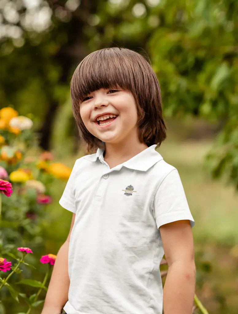 About Us polo shirt mockup of a happy kid posing beside some flowers m16569 r el2